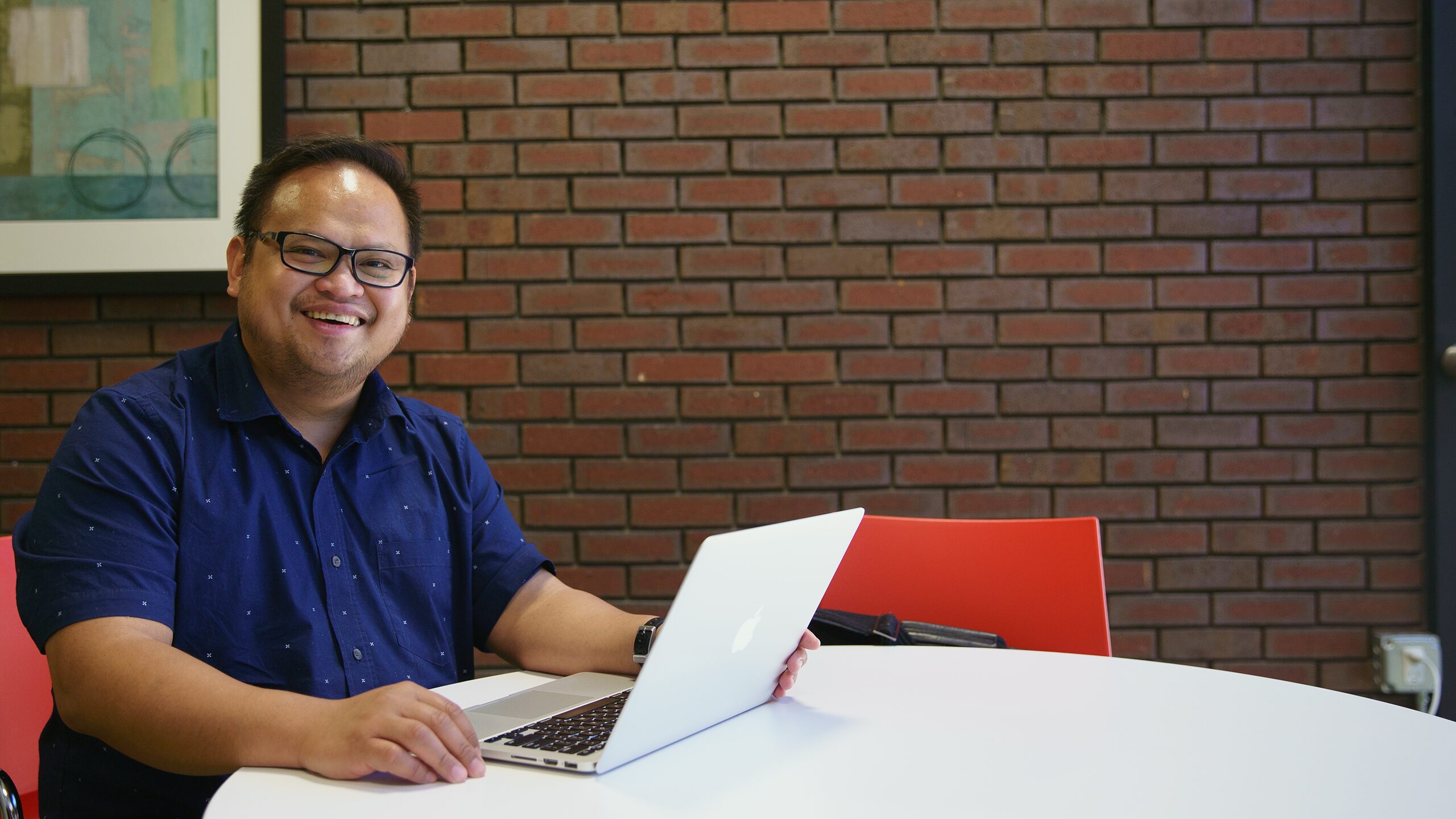 Man sitting at a table with a laptop.